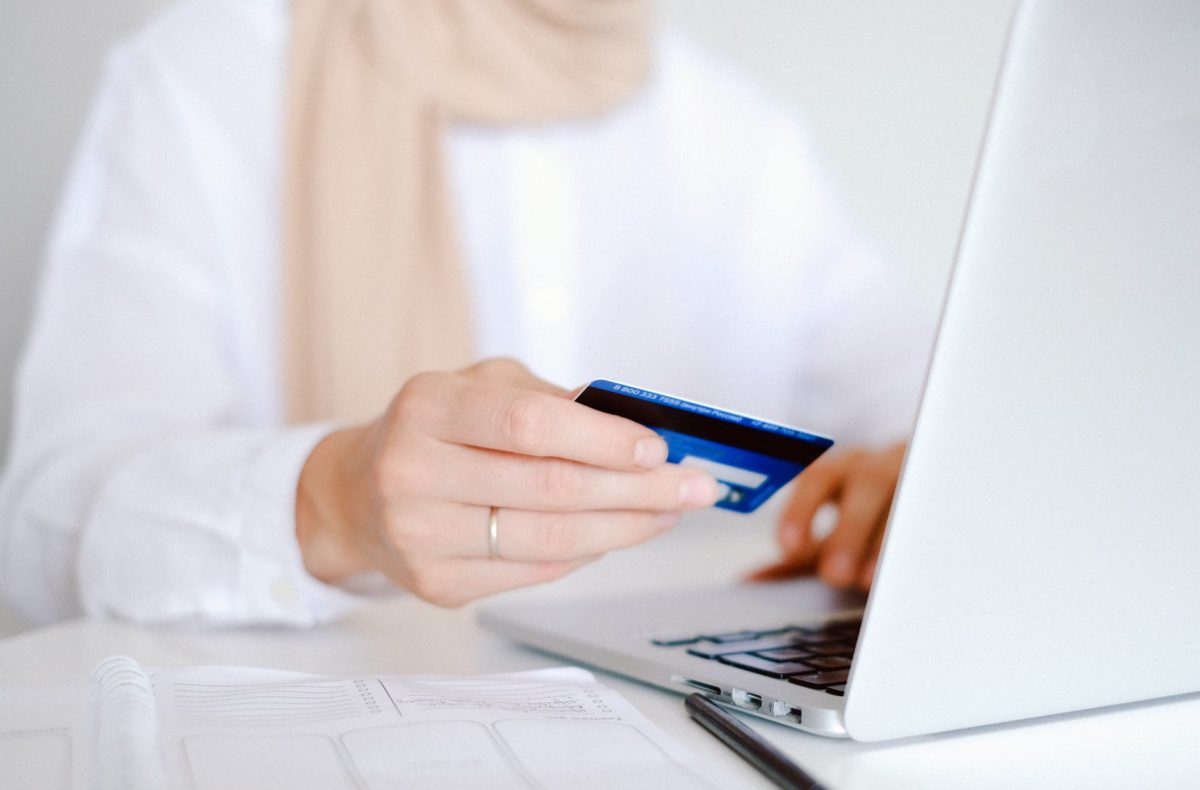 person in white long sleeve shirt holding credit card