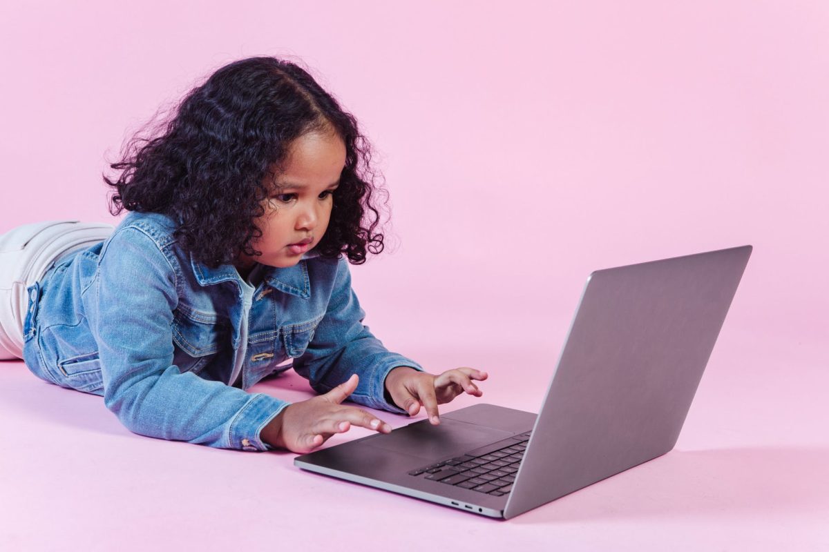 adorable black girl browsing laptop on floor